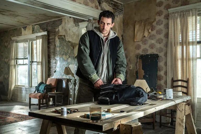 Josh O’Connor balící batoh v opuštěném domě v napínavé scéně ze sci-fi snímku Den odhalení. KULTINO*