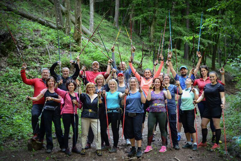 Účastníci kurzu Nordic walkingu s instruktorem Miroslavem Mirou pózující se zvednutými chodeckými holemi v lese. KULTINO*