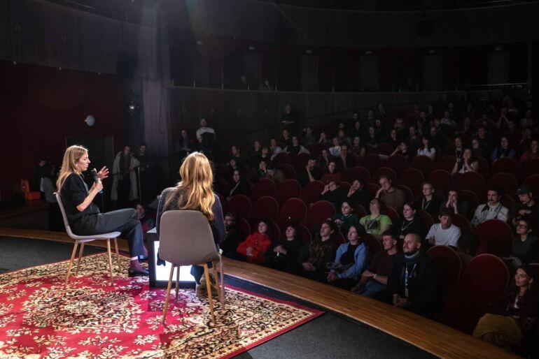 Dvě ženy v křeslech na koberci na pódiu před zaplněným hledištěm při debatě Inspiračního fóra festivalu Ji.hlava. KULTINO*