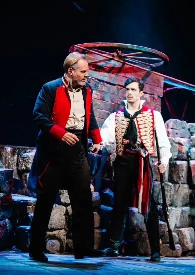 Dva herci v kostýmech před barikádou z kamenů v muzikálu Les Misérables (Bídníci) Městského divadla Brno. KULTINO*