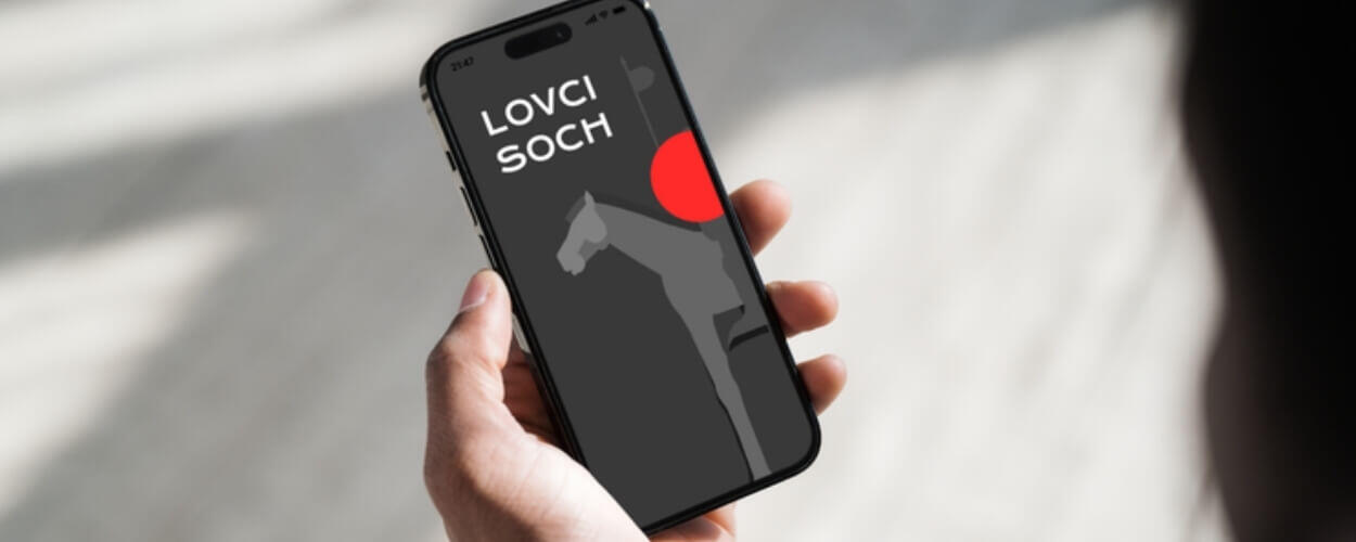 Úvodní obrazovka mobilní aplikace Lovci soch na displeji chytrého telefonu. Zábavná interaktivní hra v ulicích Brna, se kterou rodiny hravě zaženou nedělní nudu. KULTINO*