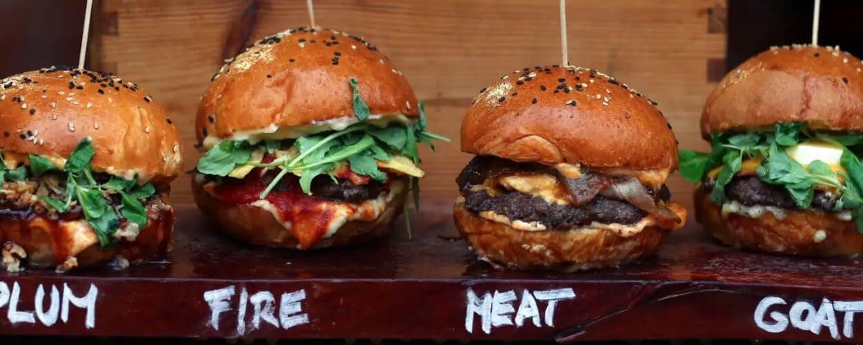 Čtveřice řemeslných miniburgerů úhledně vyskládaných na dřevěném prkénku s nápisy Plum, Fire, Heat a Goat. Kulinářský zážitek z brněnského street food festivalu, který slibuje objevování nových a nečekaných chutí. KULTINO*