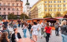 Premiérové burčákové slavnosti na náměstí Svobody v Brně. Skupinky lidí si u dřevěných stánků v historickém centru města s úsměvem užívají první letošní burčák. KULTINO*